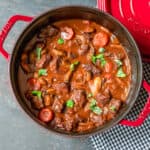 Julia Child's Beef Bourguignon Recipe served in a red Dutch oven.