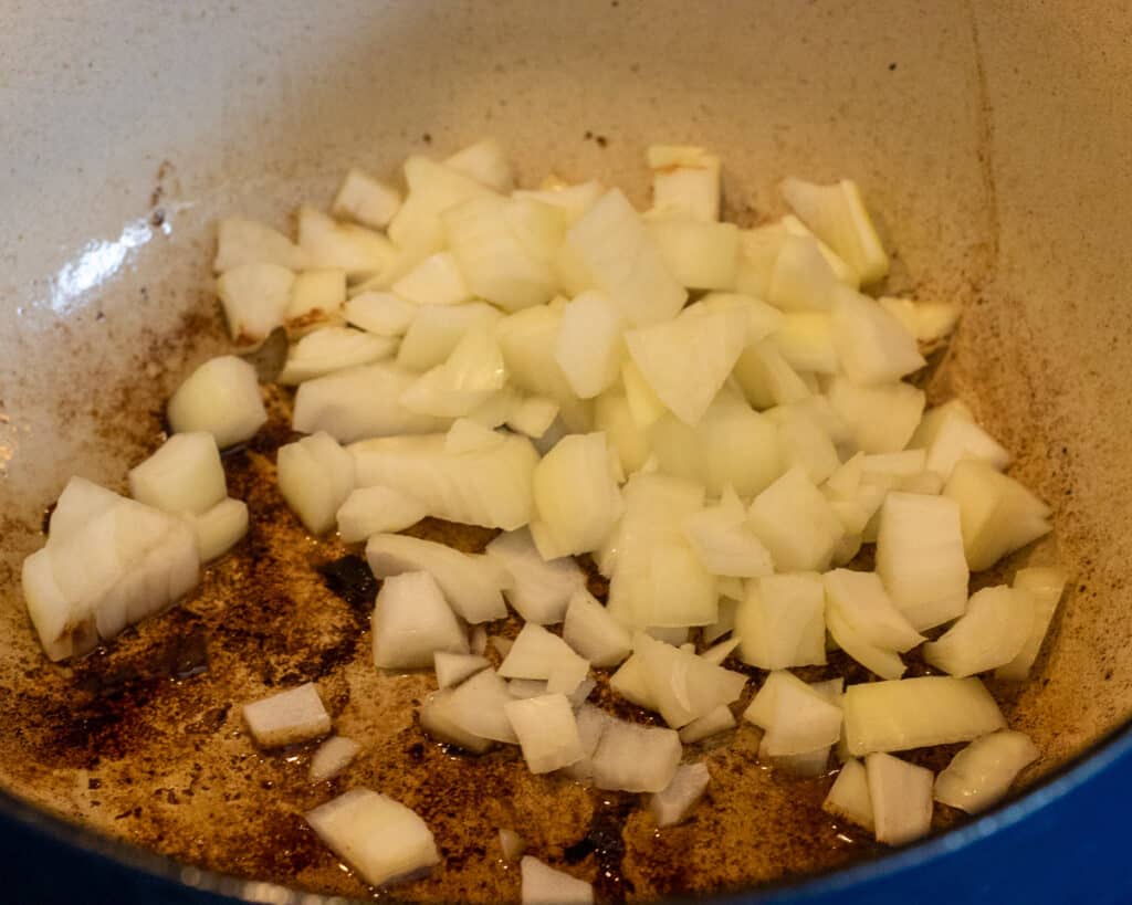 Sautéing the onions with the seared beef.