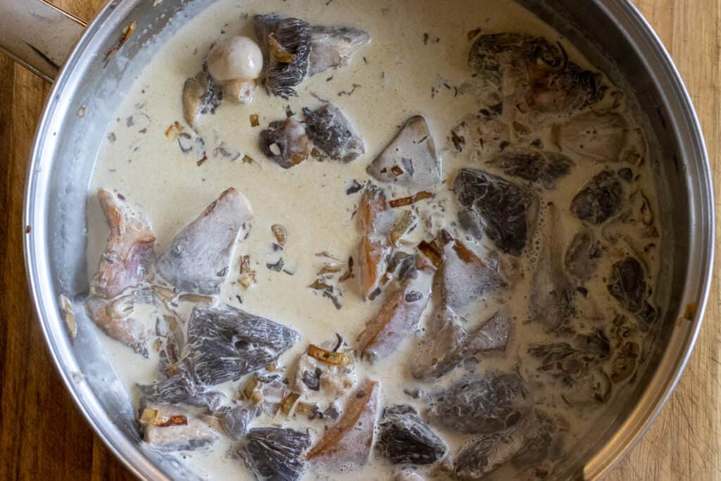 Cooking the mushrooms in cream.