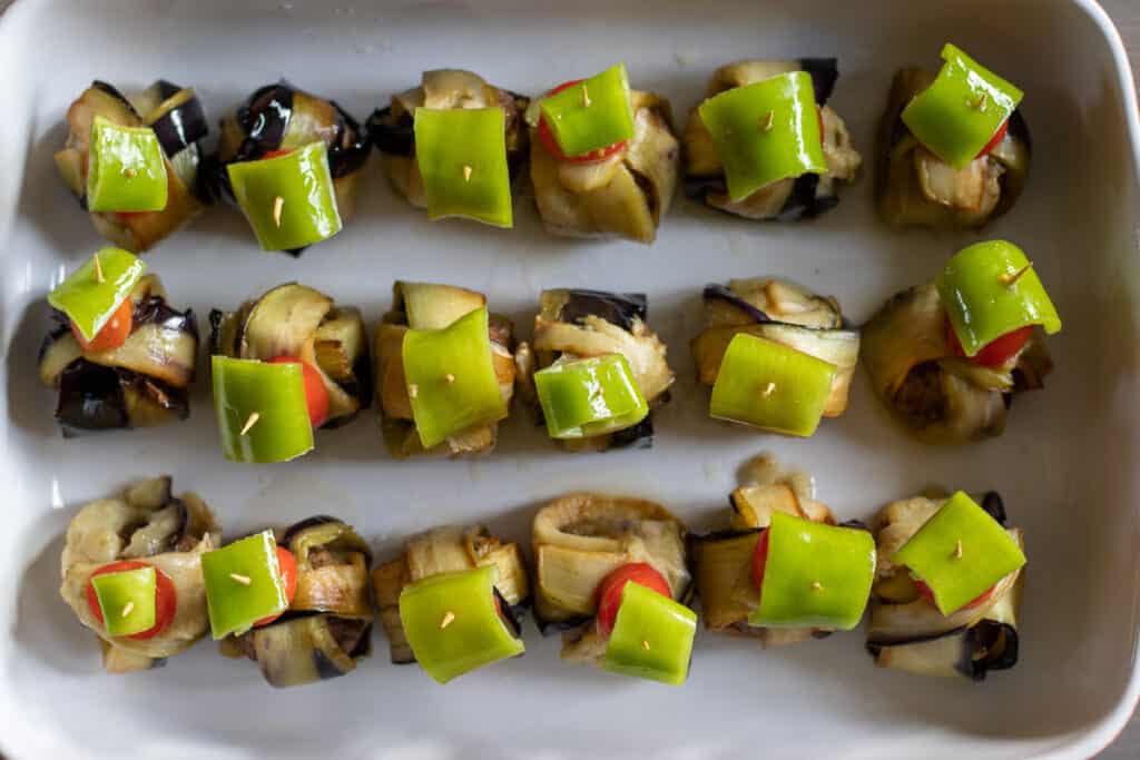 The eggplant wraps arranged in a baking dish.