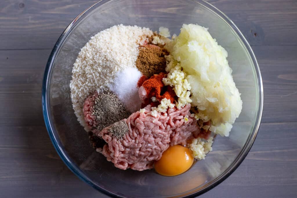 Ingredients for the meatballs in a mixing bowl.