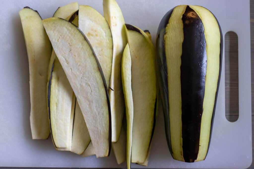 A peeled eggplant sliced into strips.