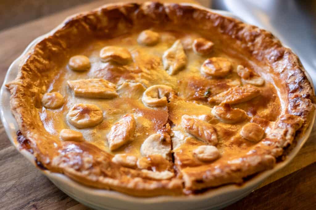 Golden baked steak pie with shortcrust pastry top, ready to serve.