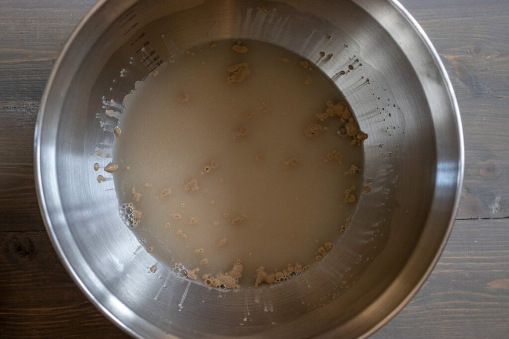 Yeast, sugar, and water are placed in a bowl.