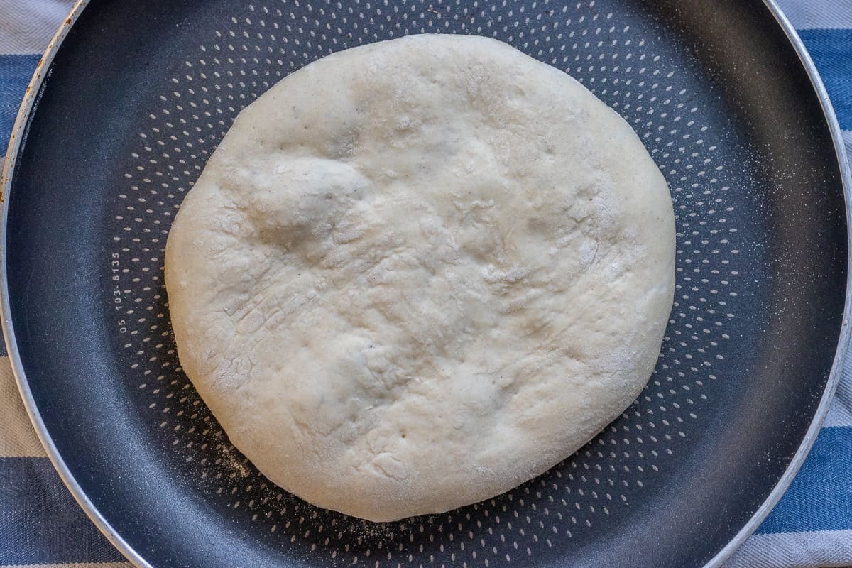 Cooking a dough circle in a hot pan.