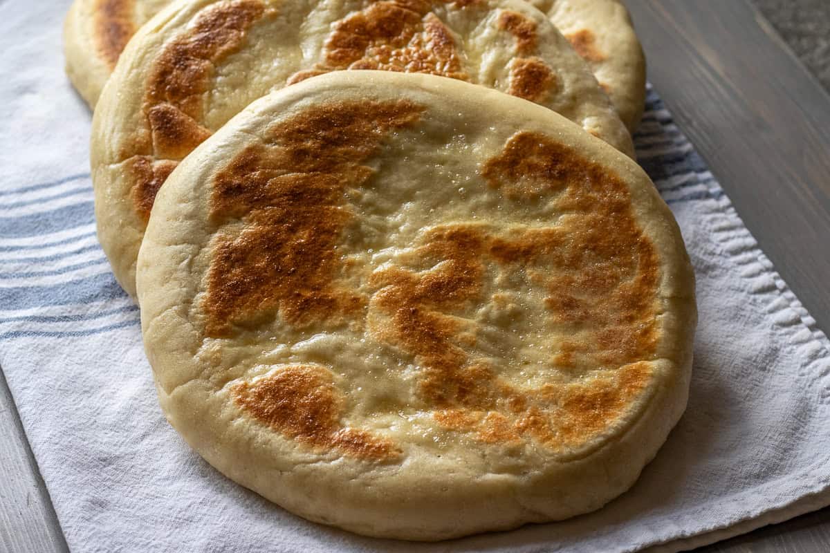 3 pieces of bazlama bread on a white cloth.