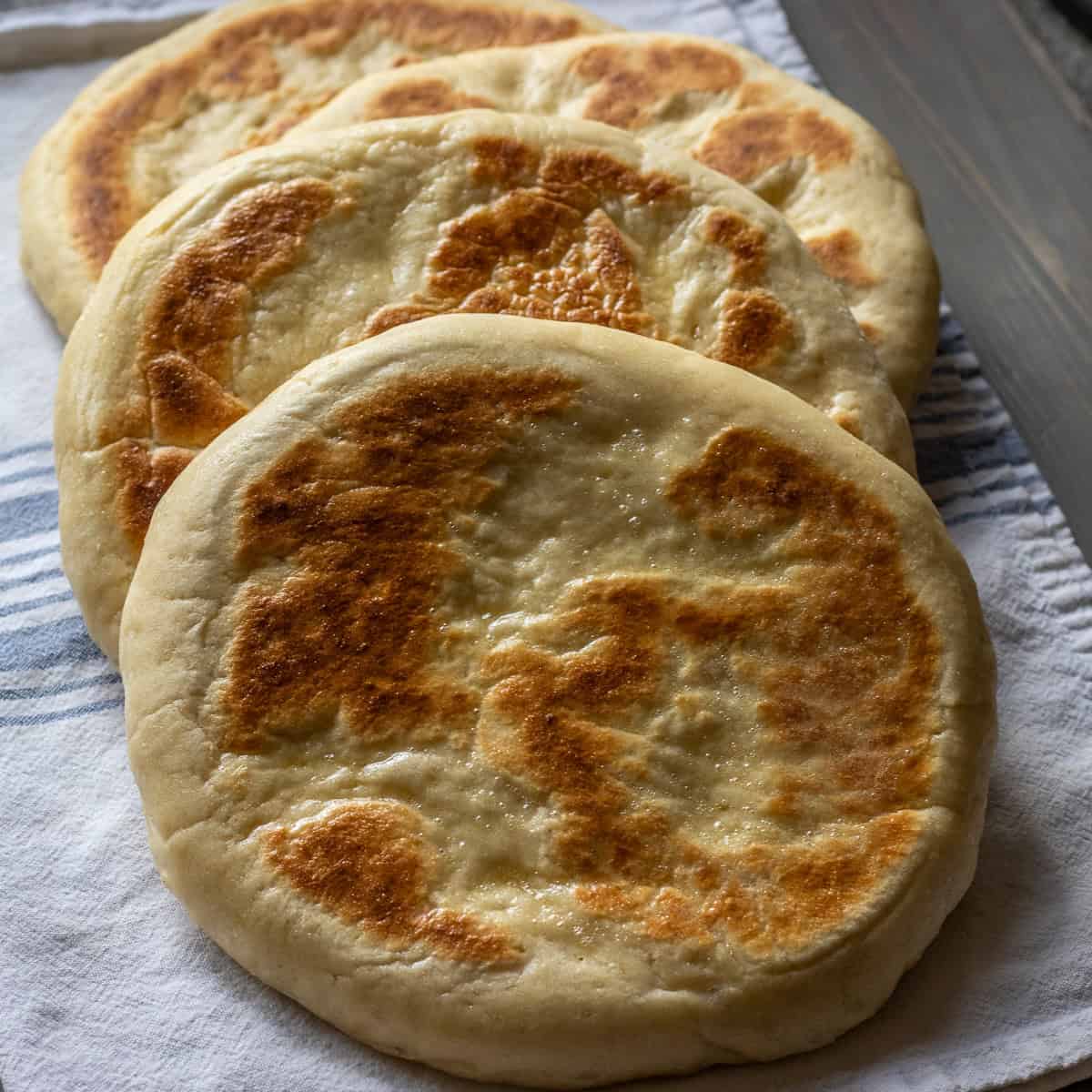 A stack of pan-cooked bazlama flatbreads.