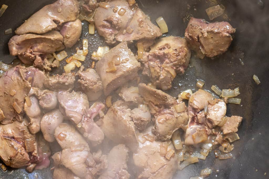 Browning the chicken livers on high heat.