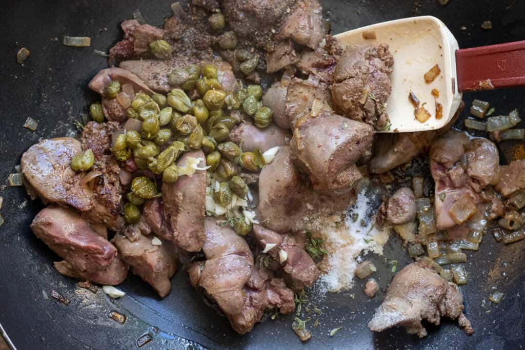 Sautéing the capers and garlic with the livers.
