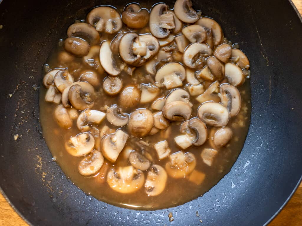 Brandy added to the mushrooms and shallots in the wok.