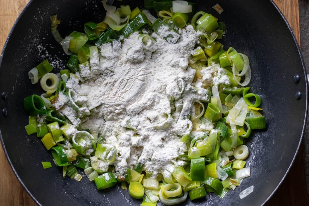 Flour sprinkled over the sautéed leeks.
