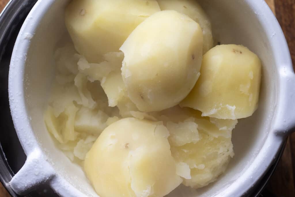 Draining the cooked potatoes in a colander.