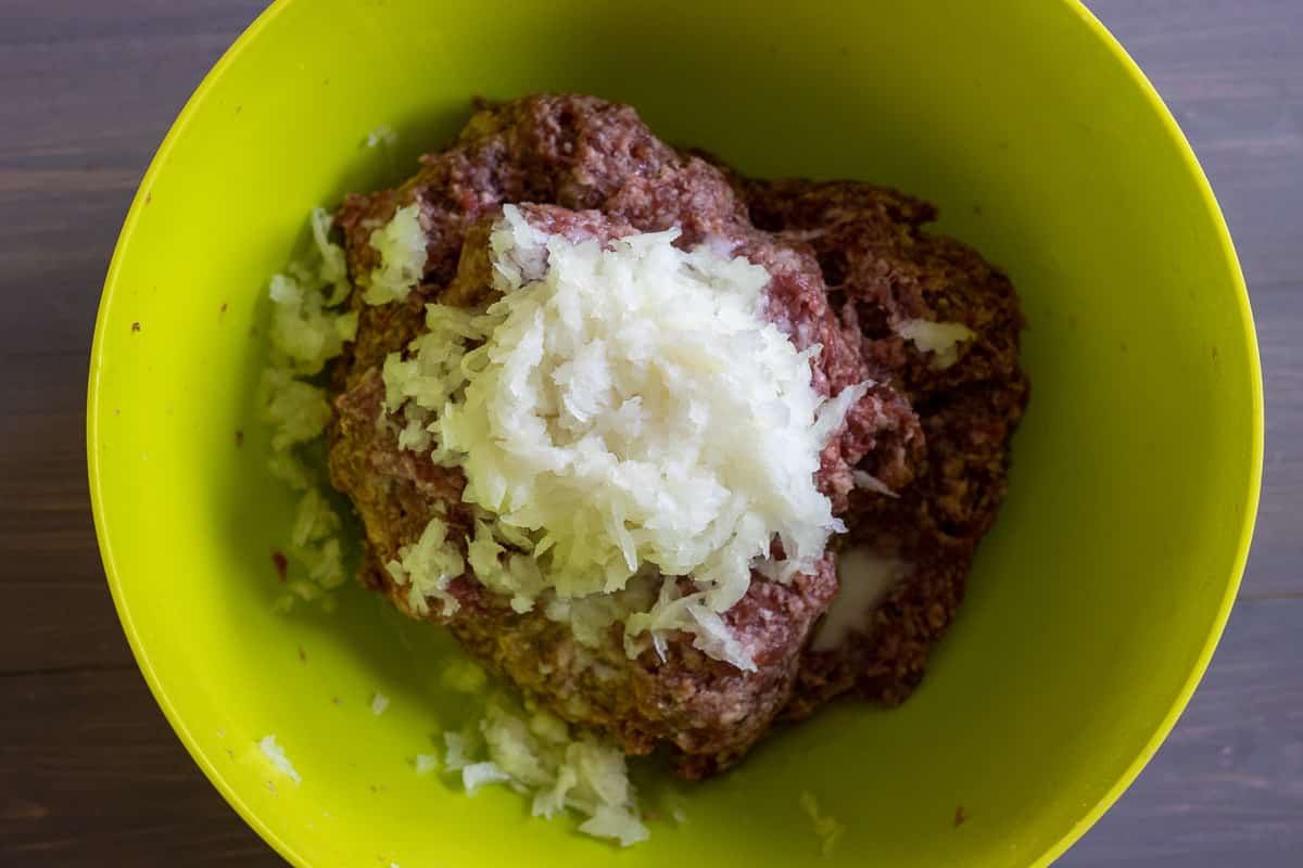 Grated onions, soda, and lemon juice are added to ground beef.