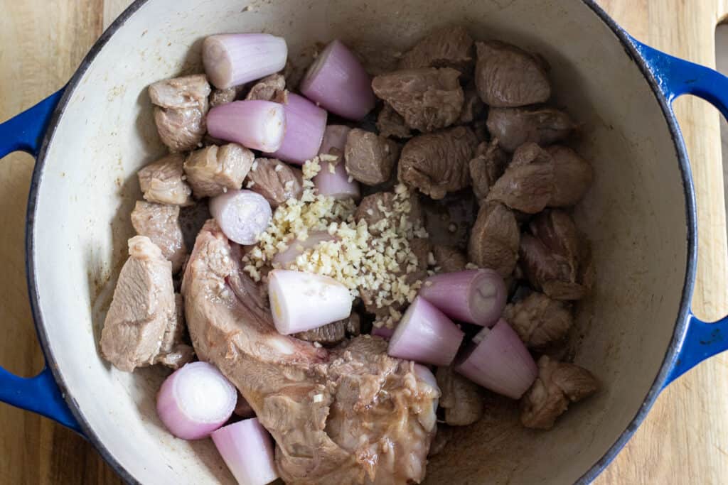 Shallots and onions added to the browned lamb.