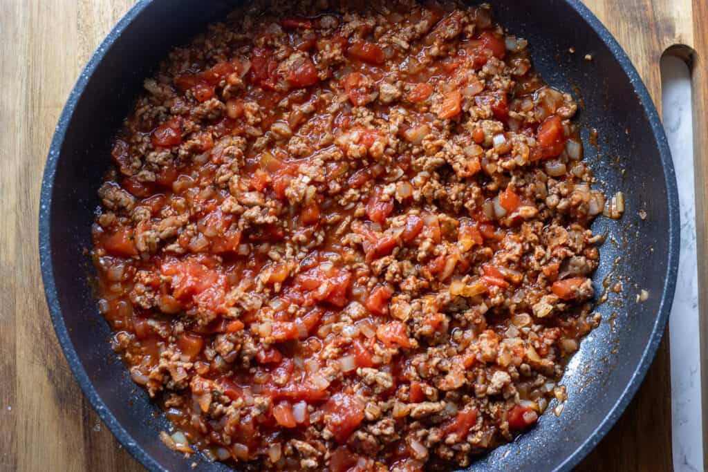 Chopped tomatoes are added to the pan.