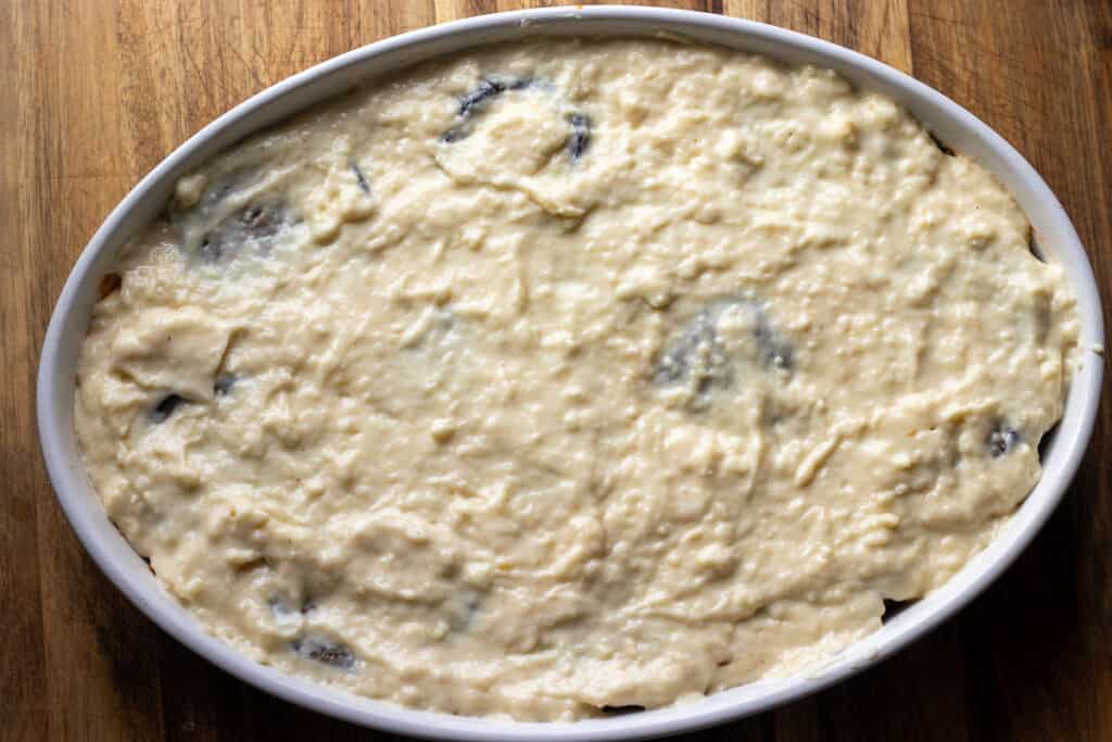 The last layer of eggplant is covered with cheese sauce.
