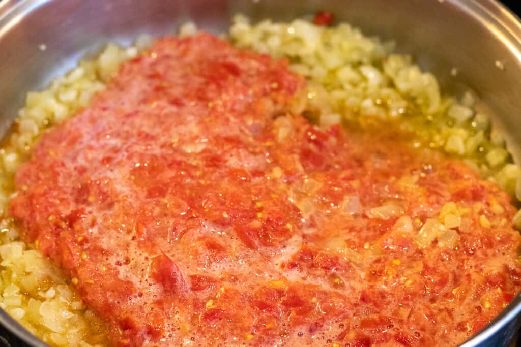 add tomatoes to sautéed onions