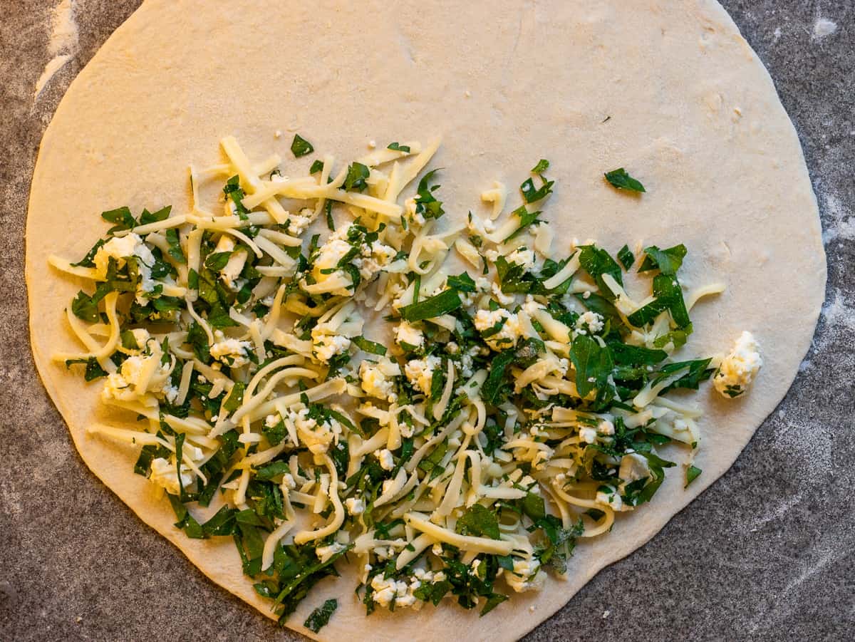 Cheese filling is placed on half of the gozleme dough.