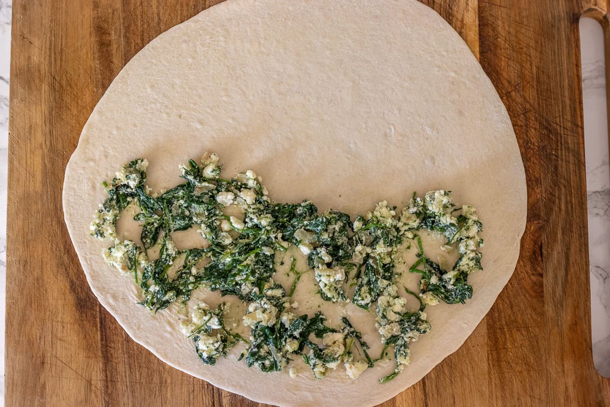 Cheese filling is placed on half of the gozleme dough.