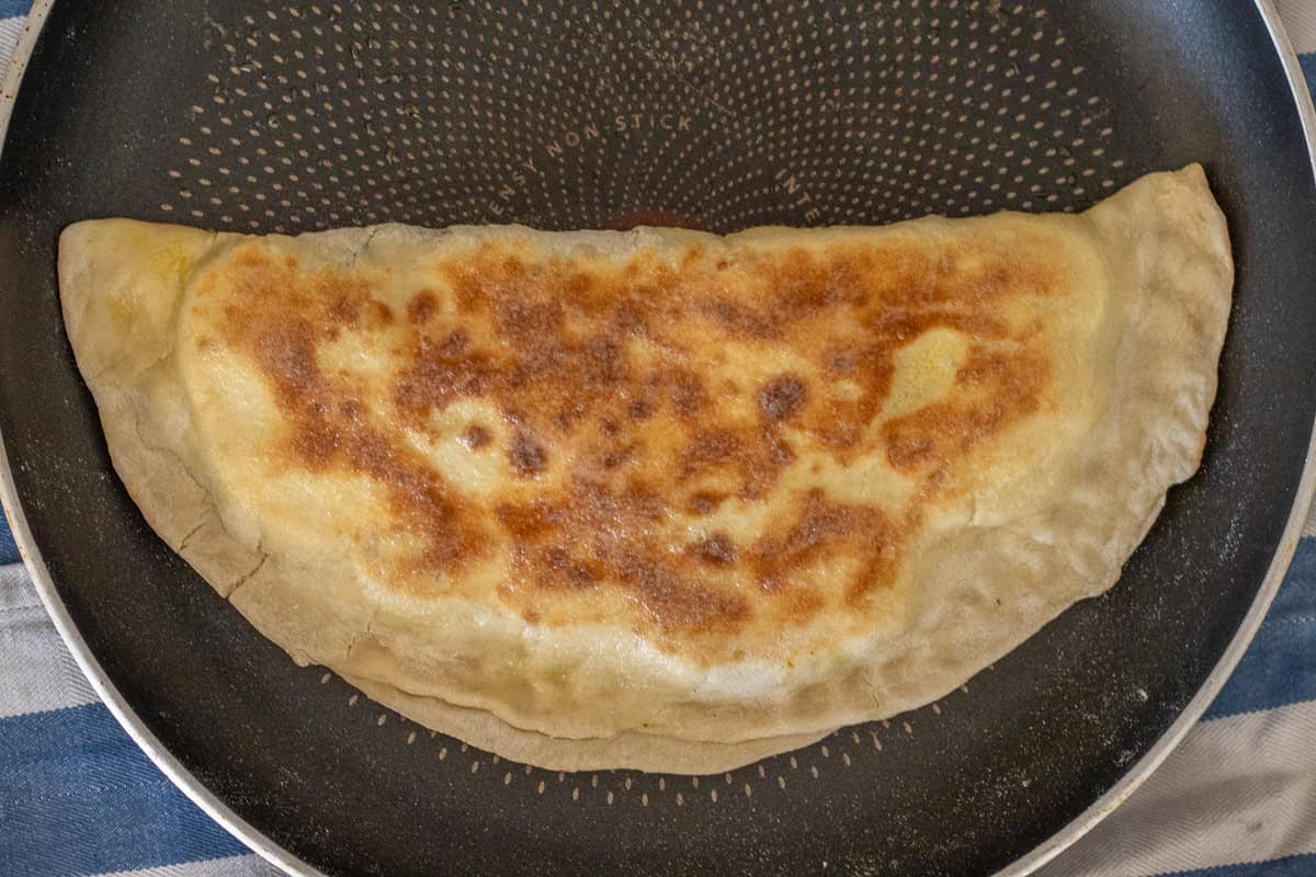 Cooking the dough in a hot pan.