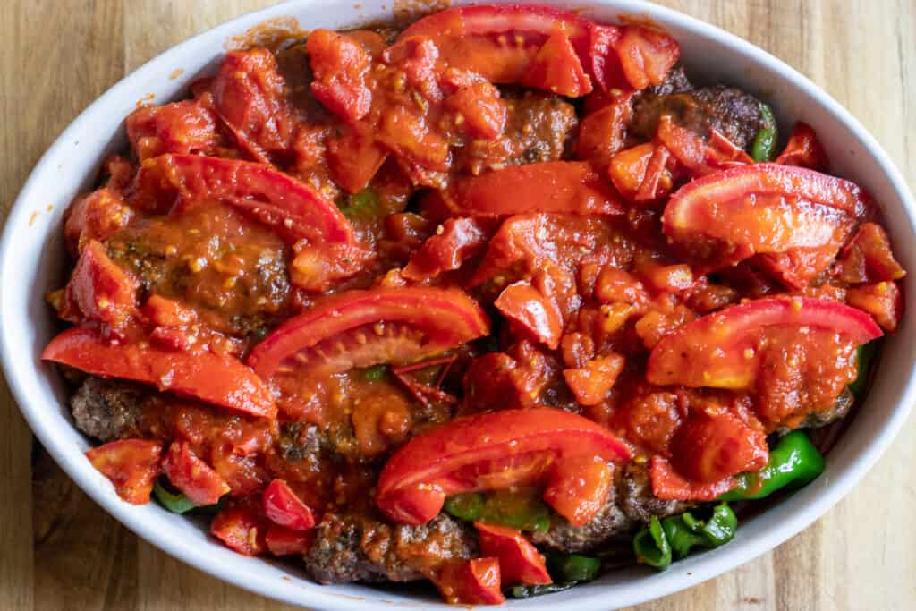 The tomato sauce is poured on meatballs and vegetables.