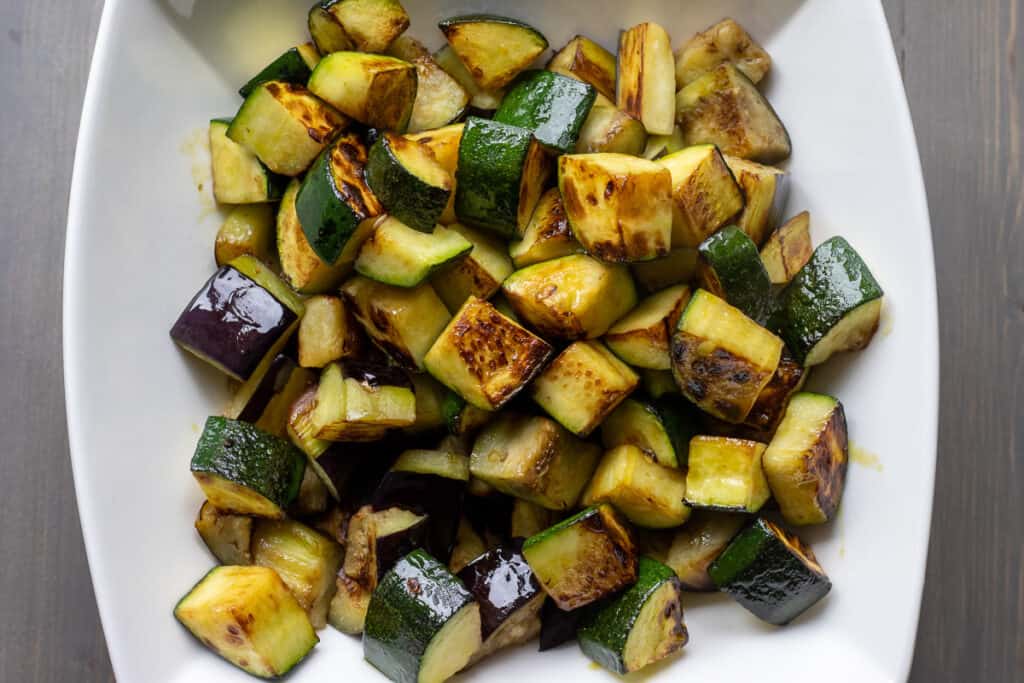 Sautéed zucchini are placed in a bowl.