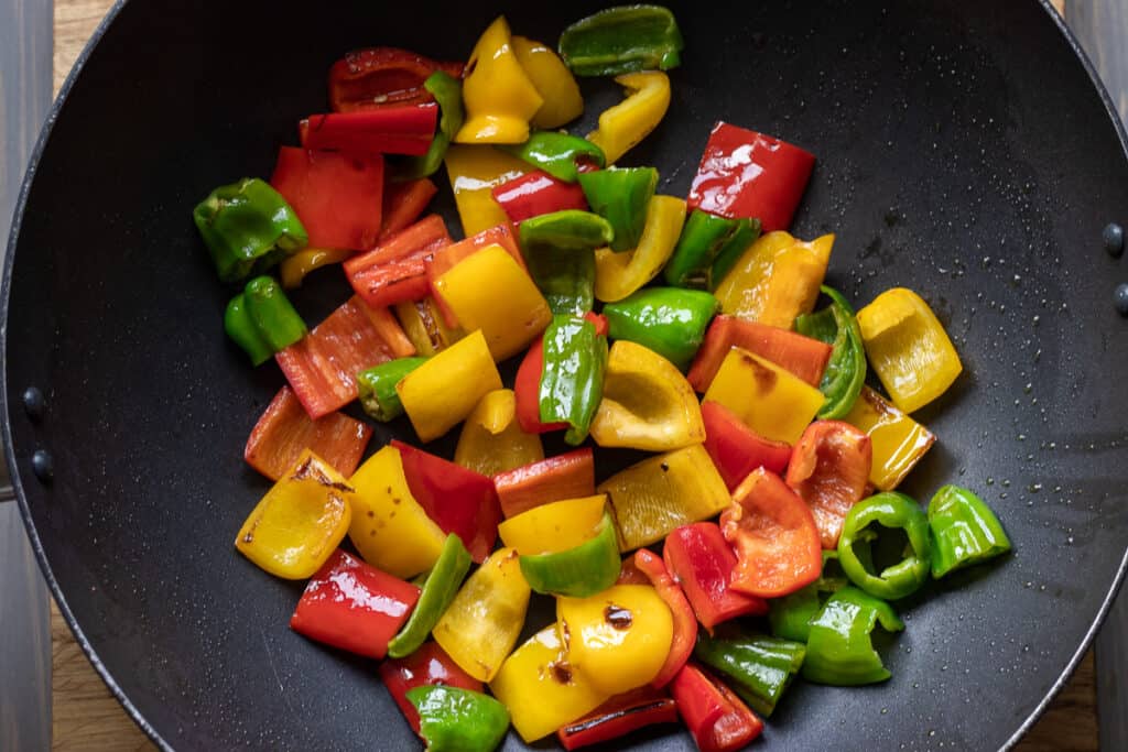 Sautéing peppers in a large pan.
