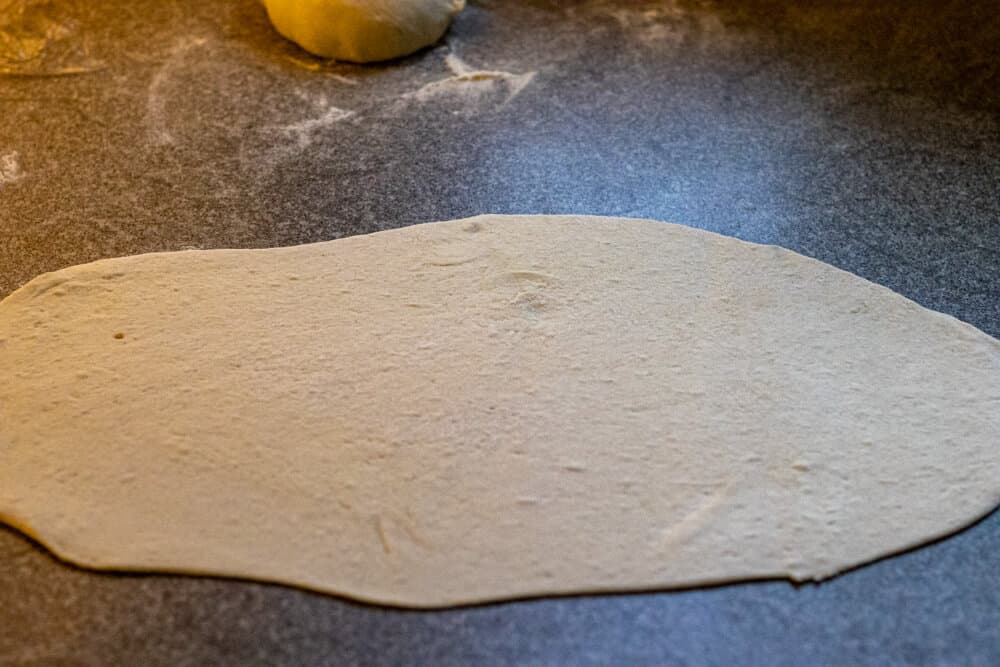 One of the dough balls rolled out into an oval shape.
