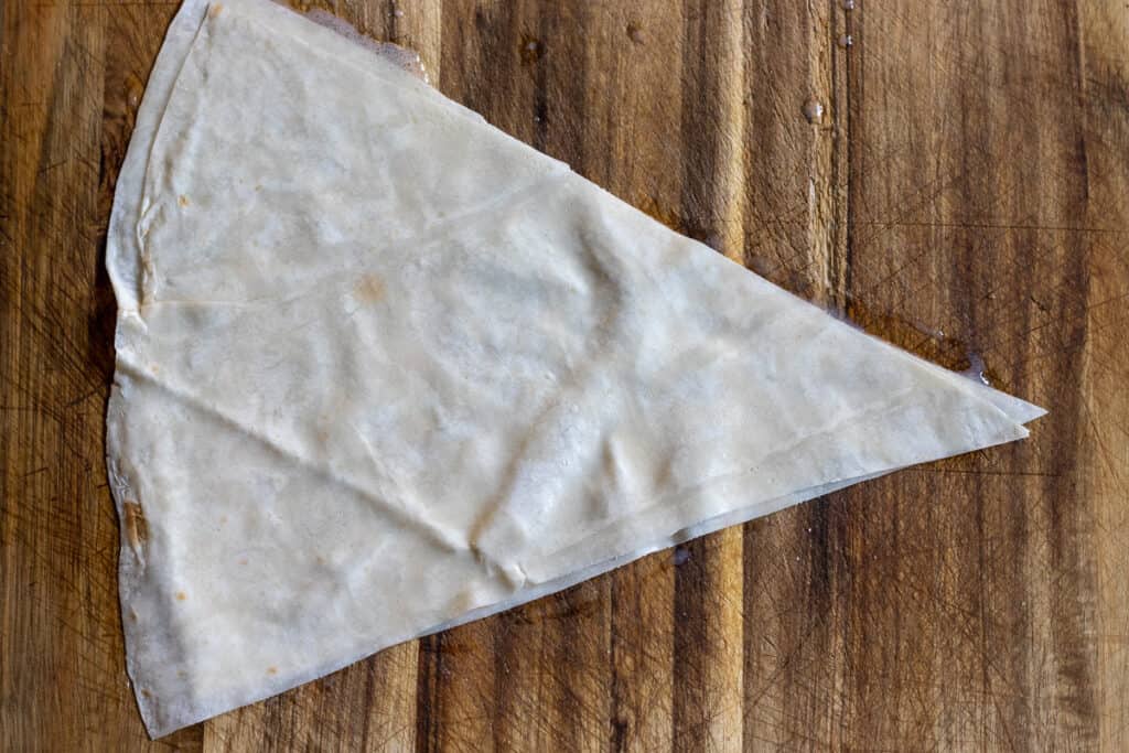2 pieces of yufka triangles are brushed with sauce.
