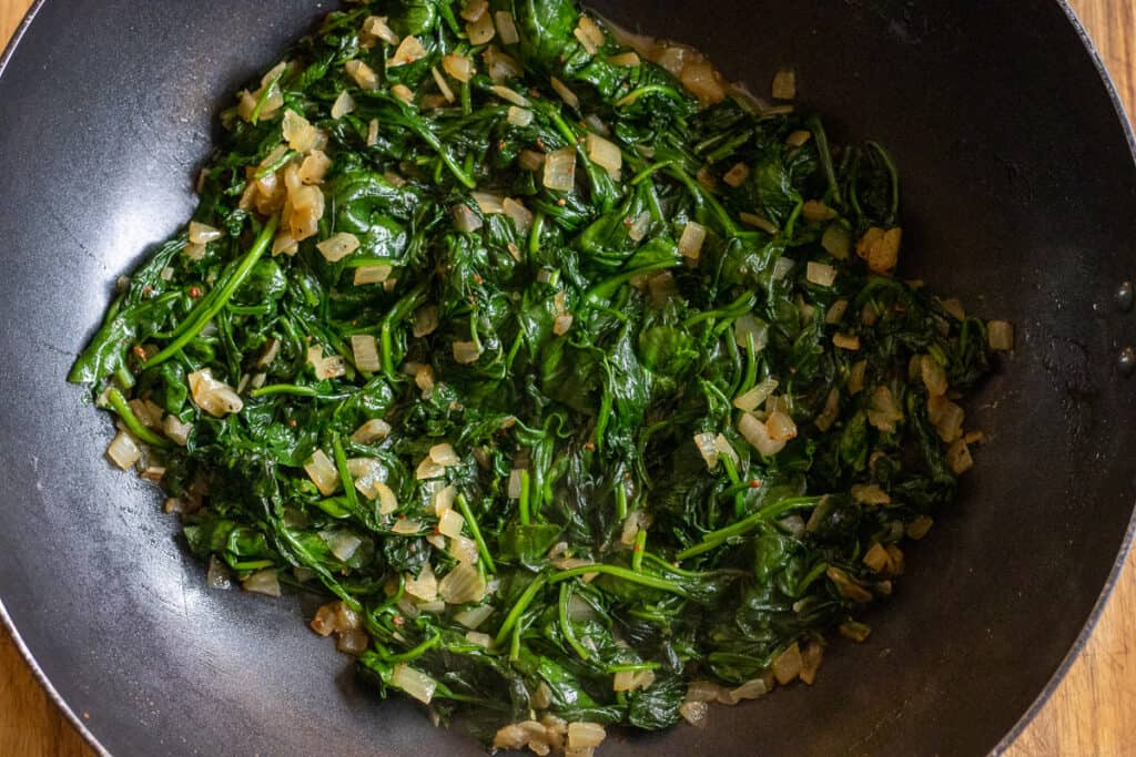 Spinach is sautéed with onions.