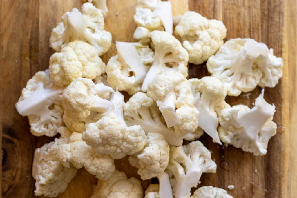 Cauliflower florets on a chopping board.