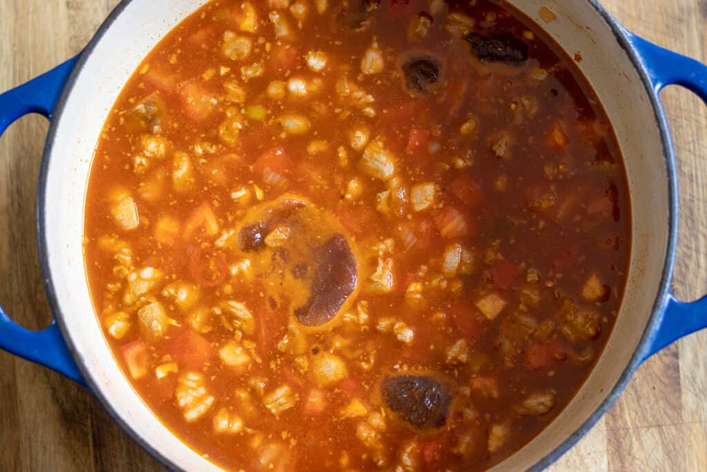 Stock poured into the pan with the lamb and tomato sauce.