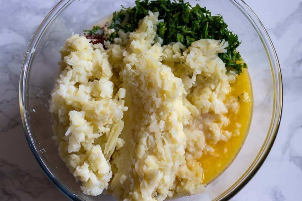 Grated potatoes, cheese and chopped parsley added to the milk mixture.