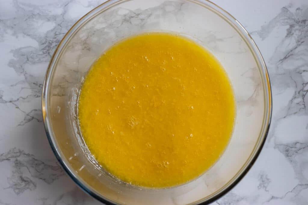 Milk, eggs and melted butter whisked in a bowl.