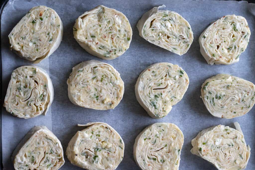 Potato borek slices arranged on a lined baking tray.