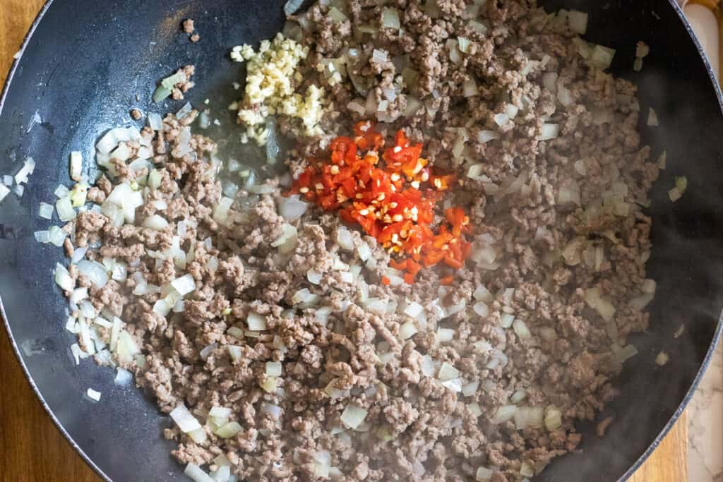 Chili and garlic are added to sautéed beef and onions.