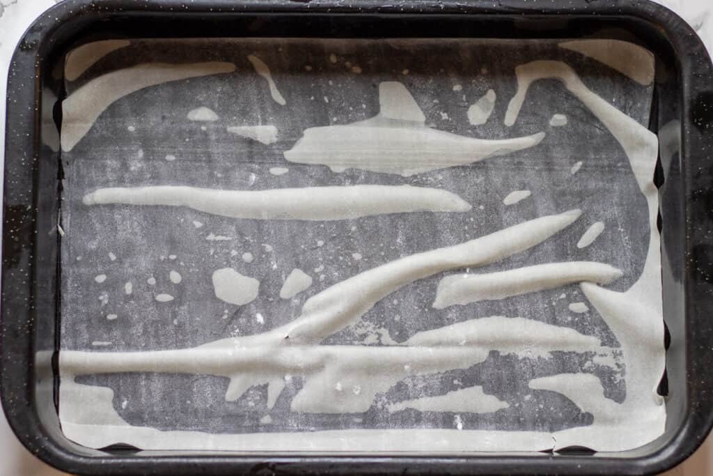 A sheet of phyllo pastry is layered in the bottom of a baking dish.