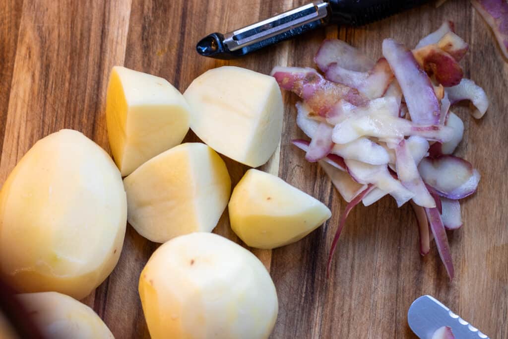 Peeled potatoes cut into large chunks.