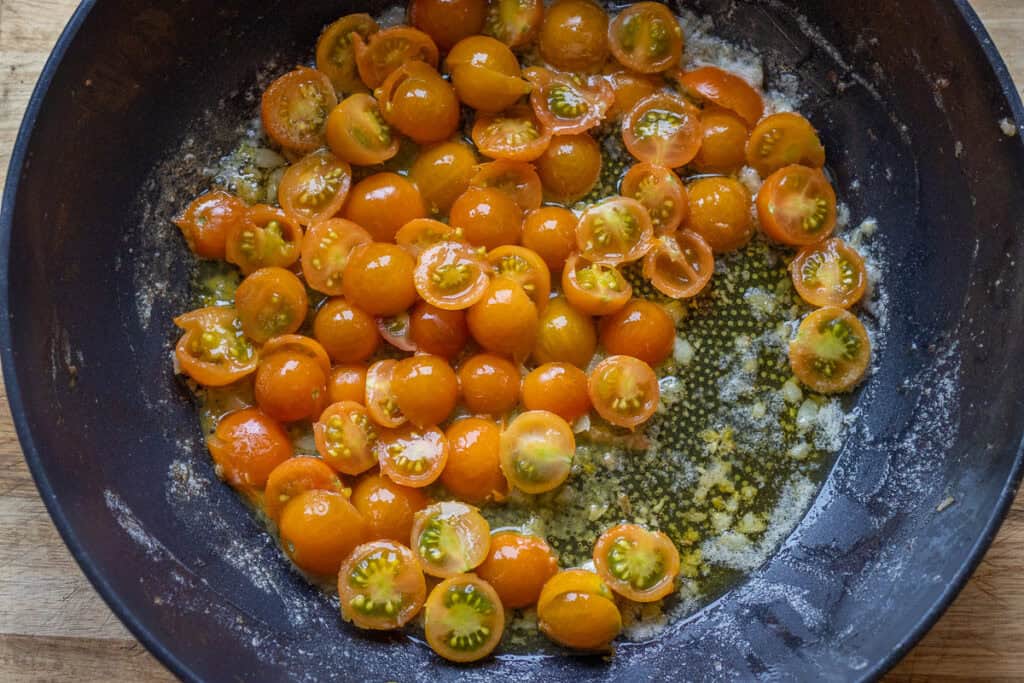 Cherry tomatoes softening in the garlic butter.