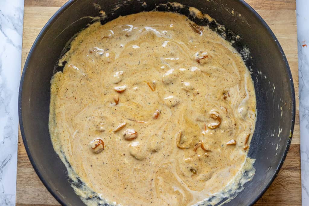 The creamy cajun sauce bubbling in the pan.