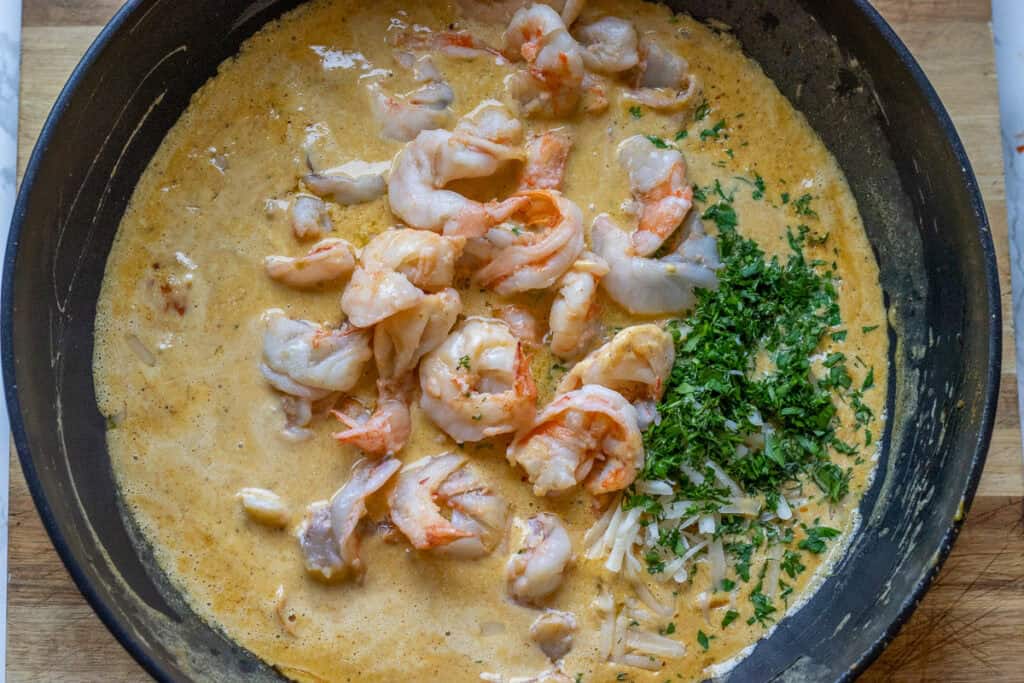 Seared shrimp returned to the creamy sauce with chopped herbs.