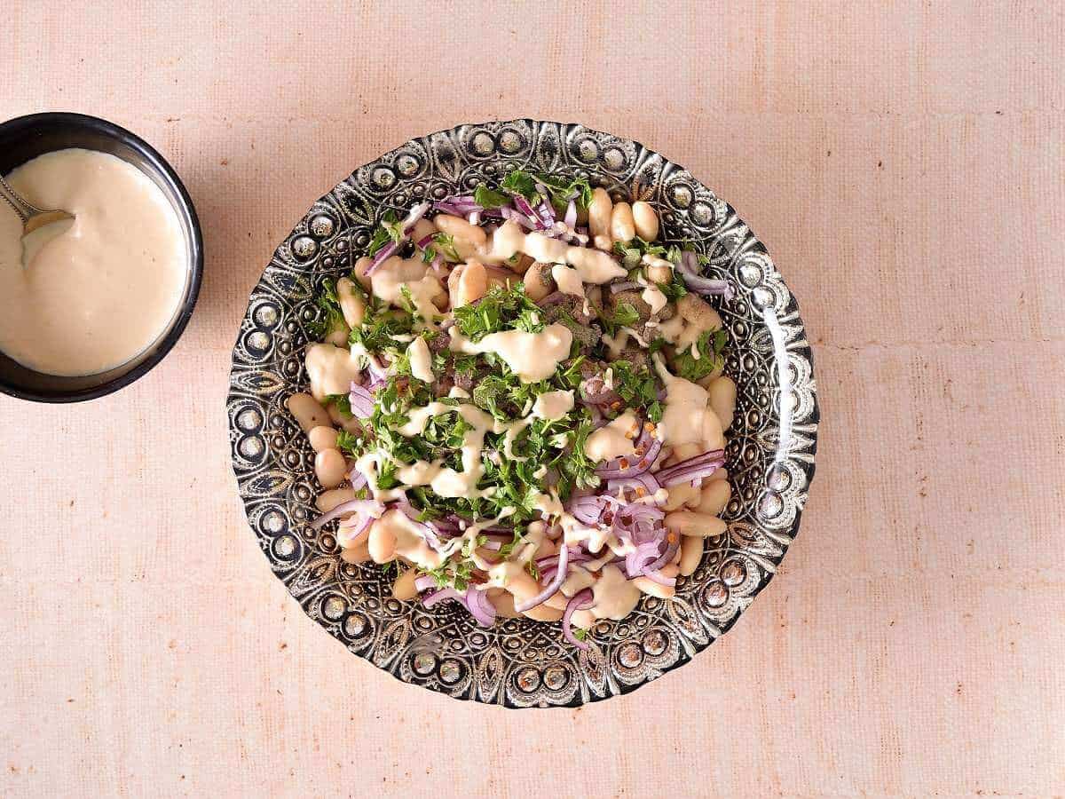 Salad is drizzled with a little tahini dressing.