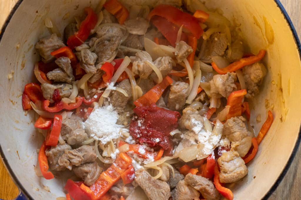 Seasoning and flour are added to the pan.