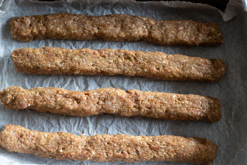 The kofta mixture is divided into 4 and shaped into a log.