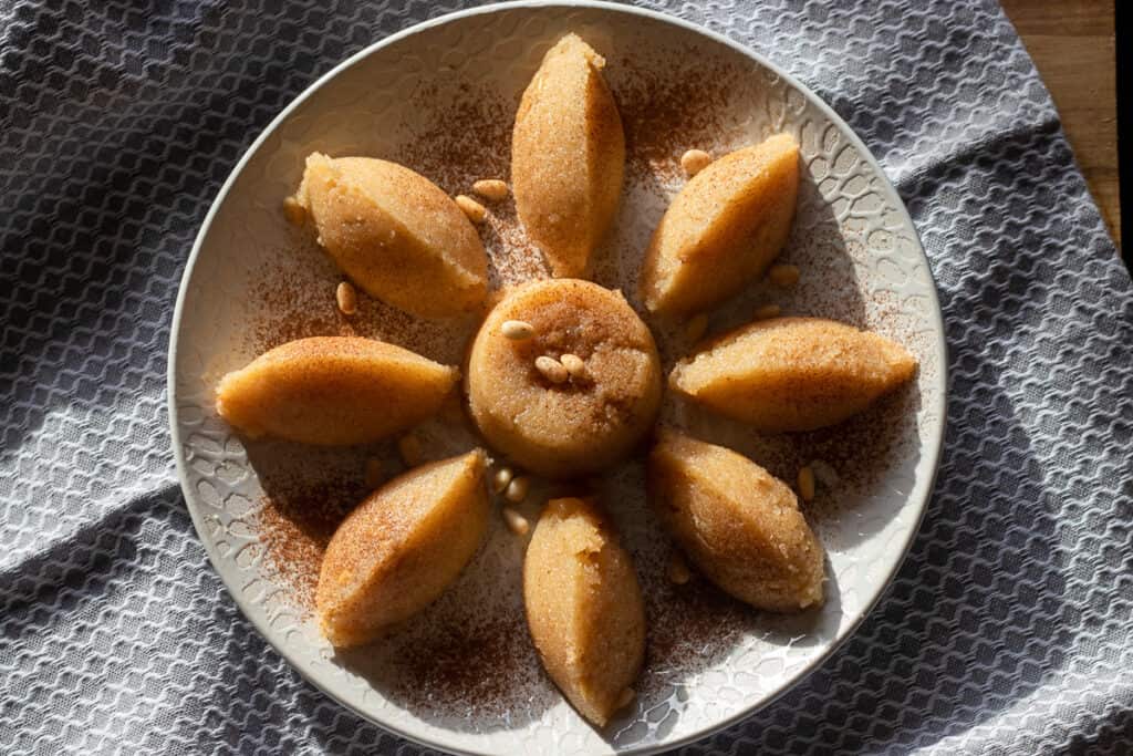 Helva shaped with two spoons into quenelles and garnished with pine nuts.