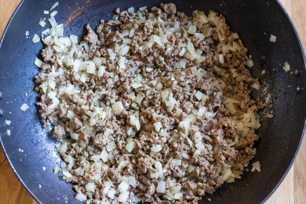 Sautéing the onions with the meat.