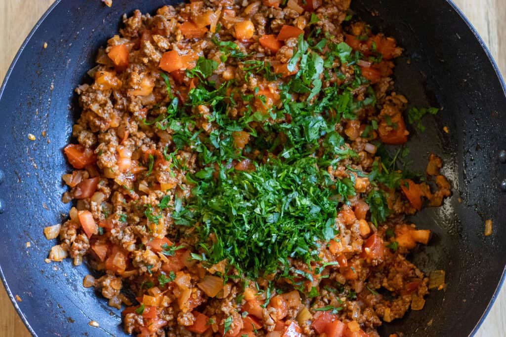 Finely chopped parsley is added to the pan.