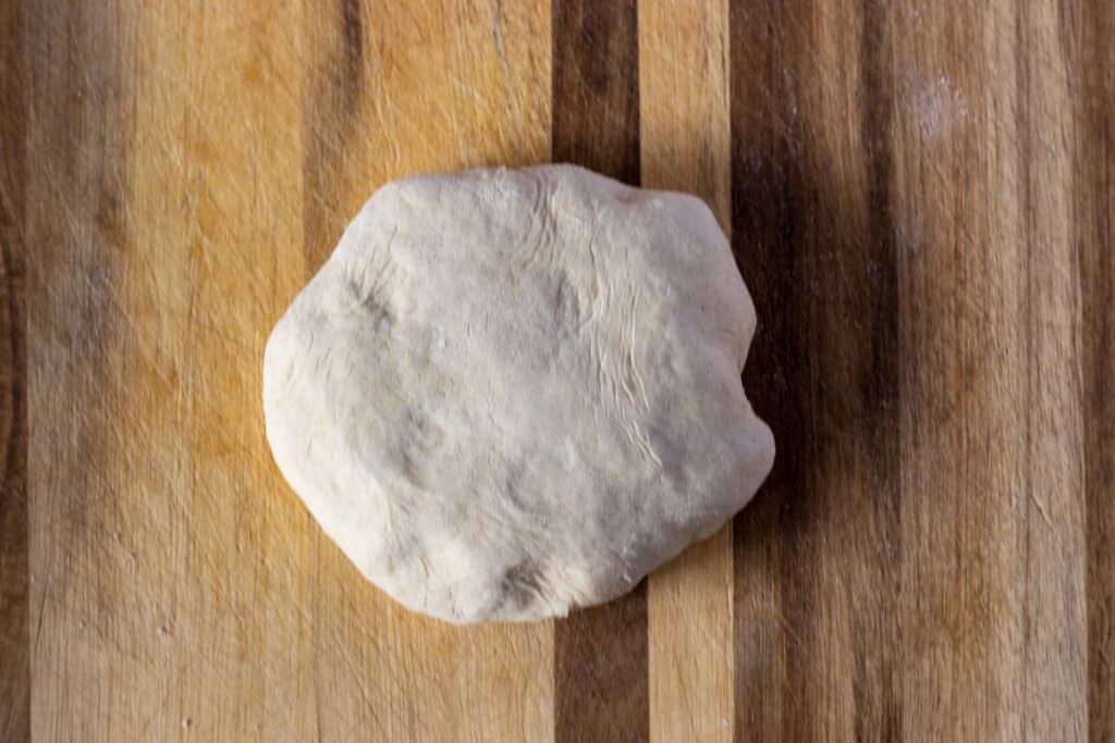 The edges are pulled up around the filling and shaped into a ball.