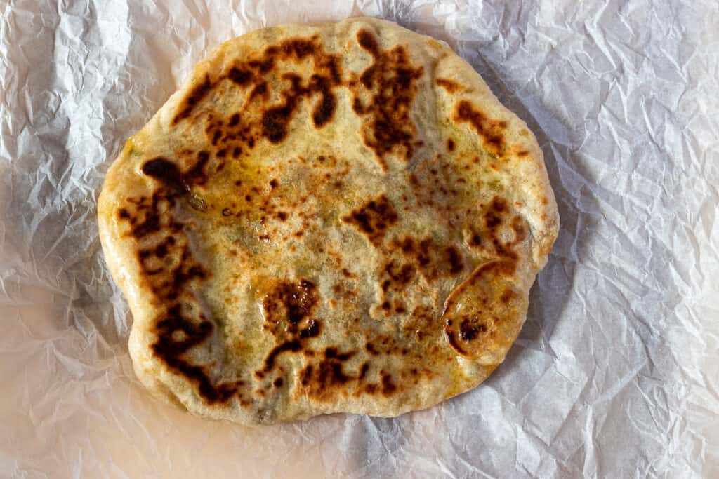 The dough is cooked until lightly charred and golden brown.