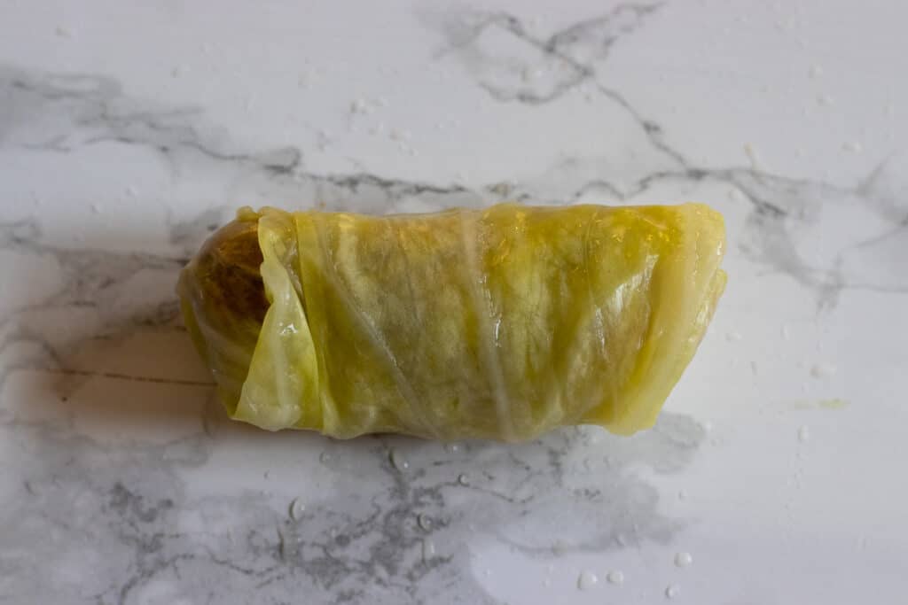 The rolled cabbage leaf gently squeezed to secure it.